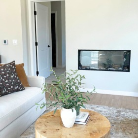 Large living room facing fire place surrounded by chairs and couch to either side