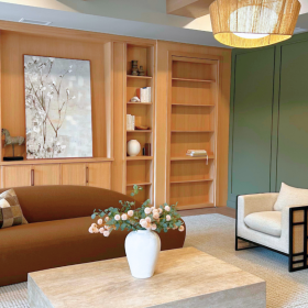 Community space with  bright lights and a brown couch sitting in front of a wall book shelf